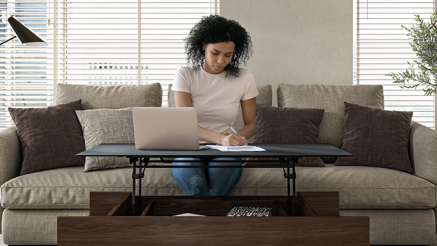 Reveal lift top height adjustable coffee table walnut bdi furniture woman working on couch