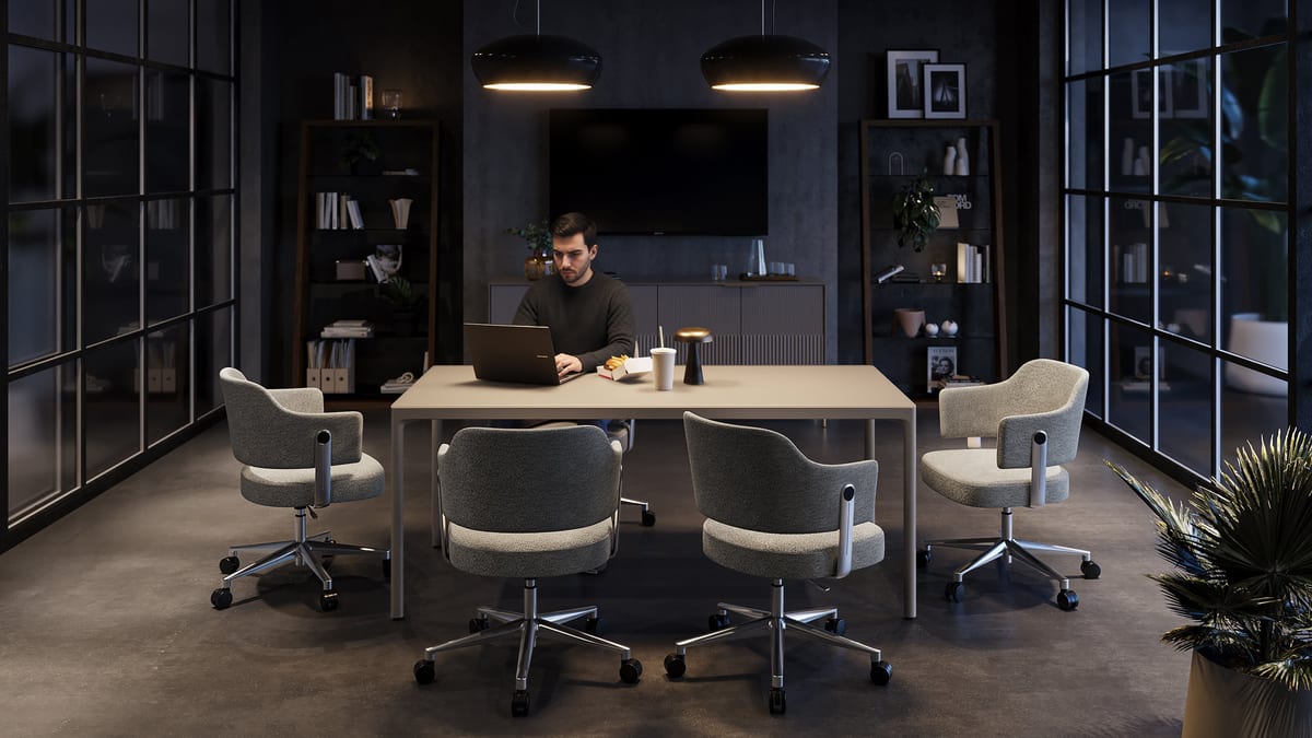 BDI Luma Desk in Dune shown in an evening office setting with a person working at the expansive desktop.