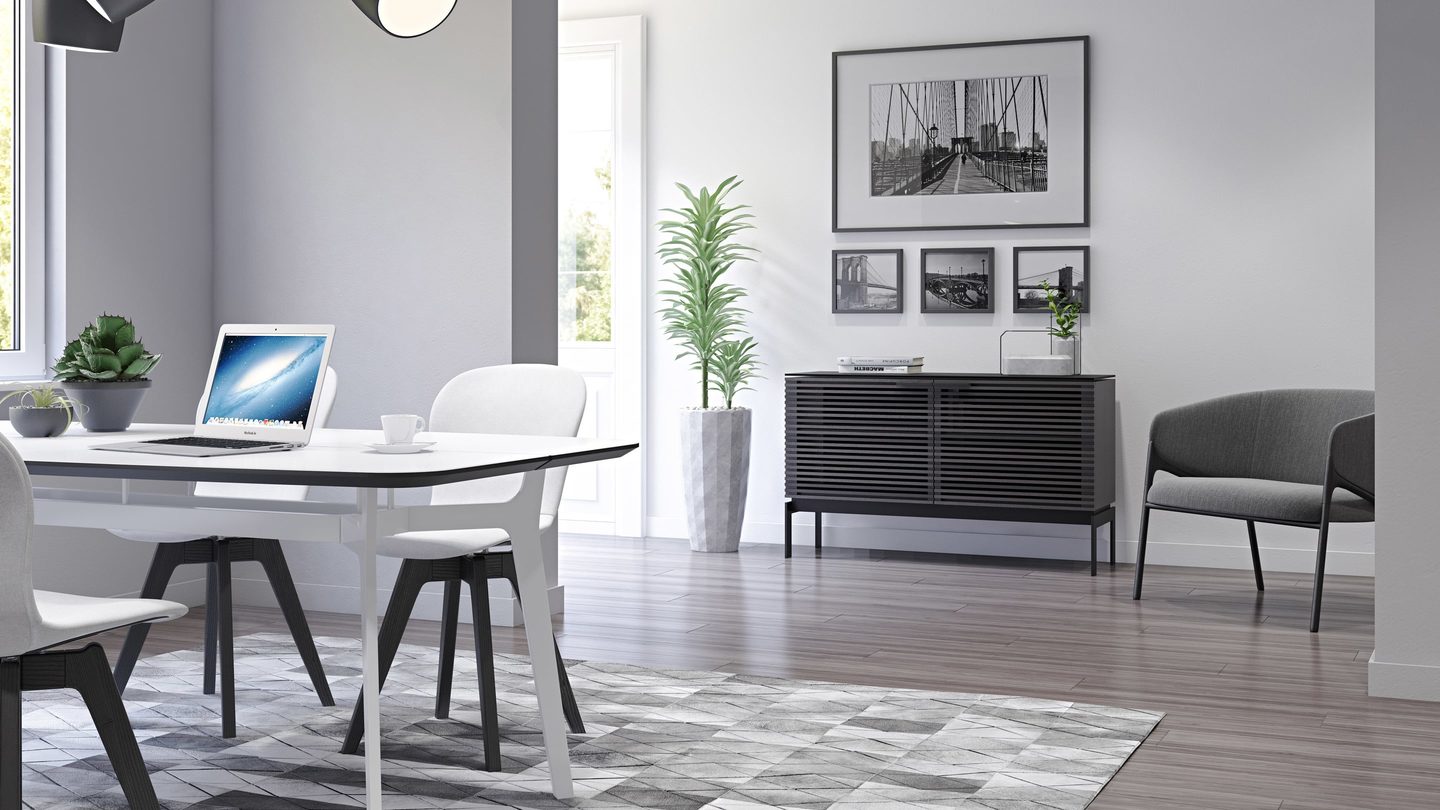 The Corridor SV 7128 in charcoal finish is on display in a hallway, upon a grey hardwood floor, off of a modern kitchen dining area.