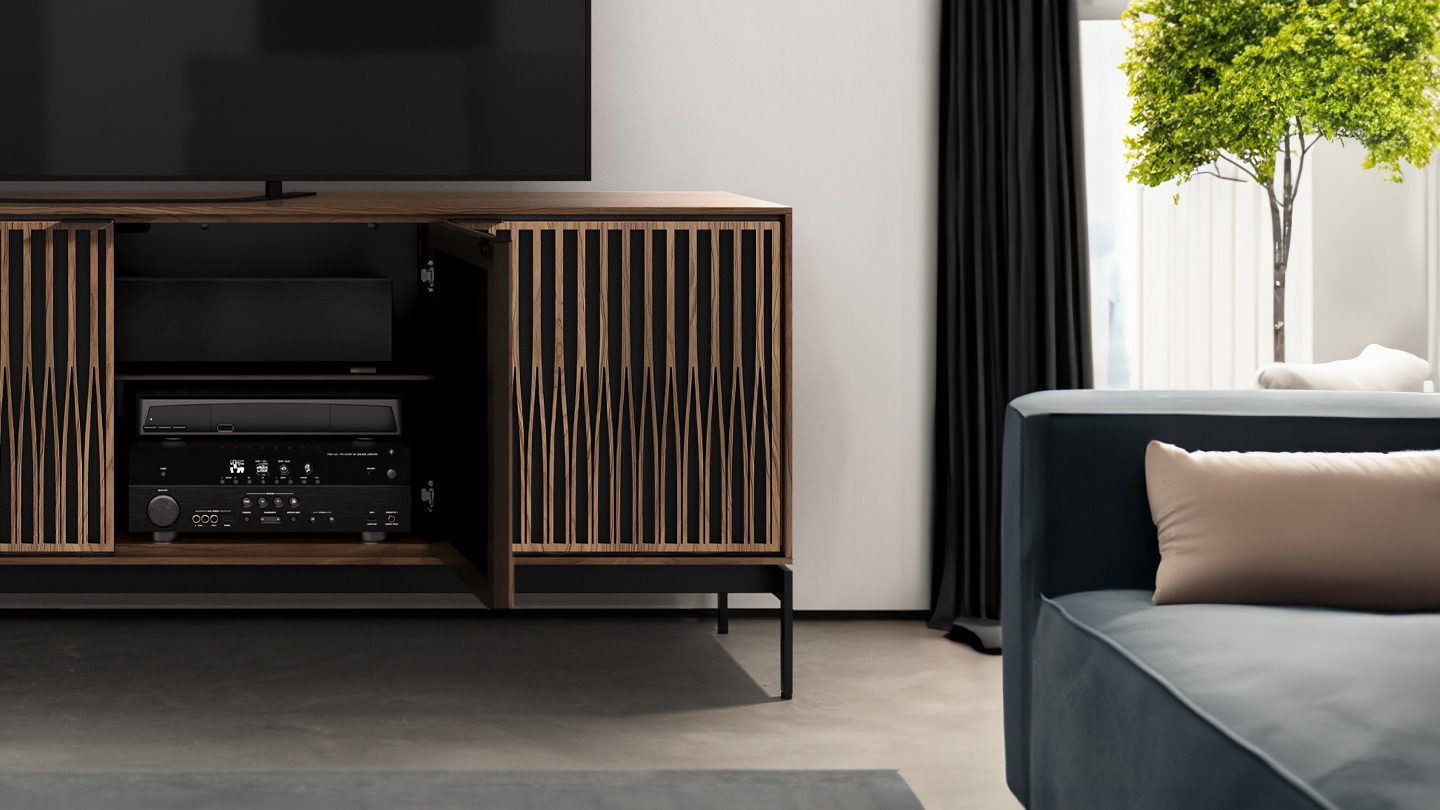 Close-up in a living room of the Elements media stand and storage credenza with the precision-cut Tune door pattern and natural walnut finish by BDI Furniture.