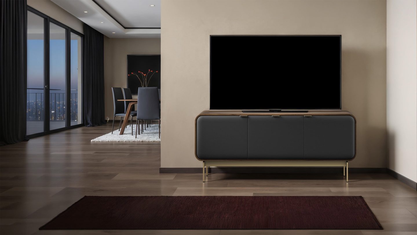 BDI Plume three-door media cabinet in Natural Walnut with black acoustic doors supporting a TV in a modern living room.