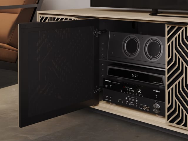Elements 8703 TV stand by BDI Furniture, shown with one door open to reveal a soundbar and AV equipment behind acoustically transparent and ventilated doors. It is displayed with the Weave door pattern in a washed oak finish.