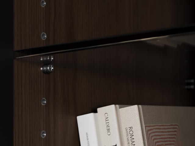 Close-up image of the threaded shelf pins used to adjust the interior tempered glass shelves of an Elements media and storage cabinet by BDI Furniture. The inserts also include a vibration-dampening rubber O-ring for increased stability.