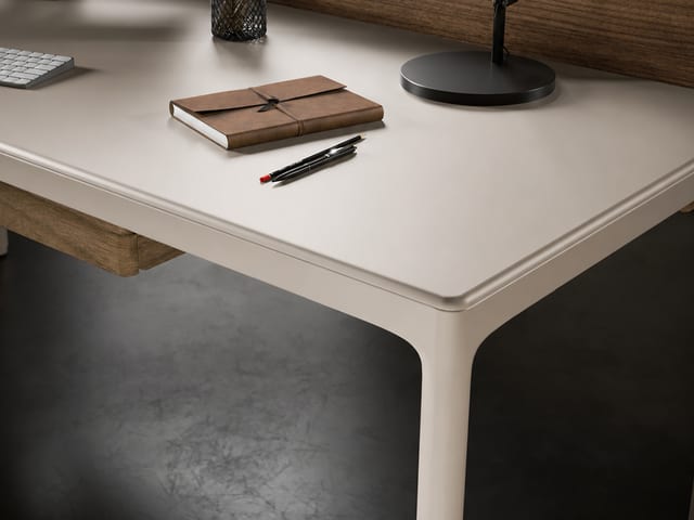 Close-up of the BDI Luma Desk in Dune showing the softly beveled satin-etched glass edge.