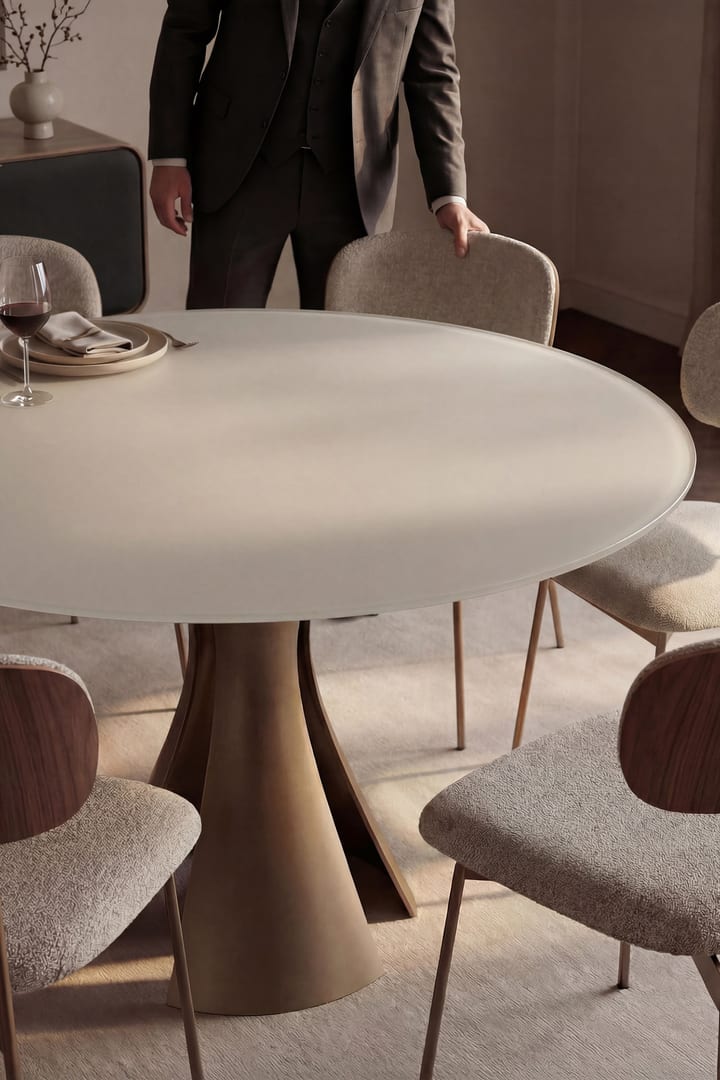 BDI Bloom 7722 60-inch round dining table with Oyster glass top and Bronze sculptural steel base in a modern dining setting.